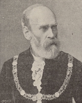 Black-and-white portrait of an older man with a beard, wearing formal attire and an ornate chain of office, looking slightly to the side.