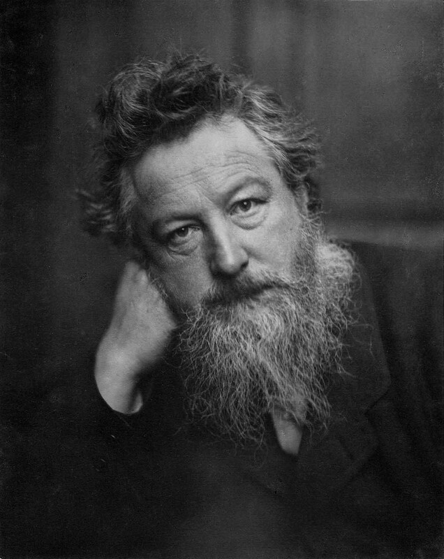 Black-and-white portrait of a bearded man with tousled hair, resting his head on his hand, gazing thoughtfully at the camera.